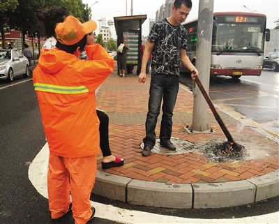 昨日，清洁工许女士的家人在她被撞的地点烧纸寄托哀思。新京报记者 左燕燕 摄